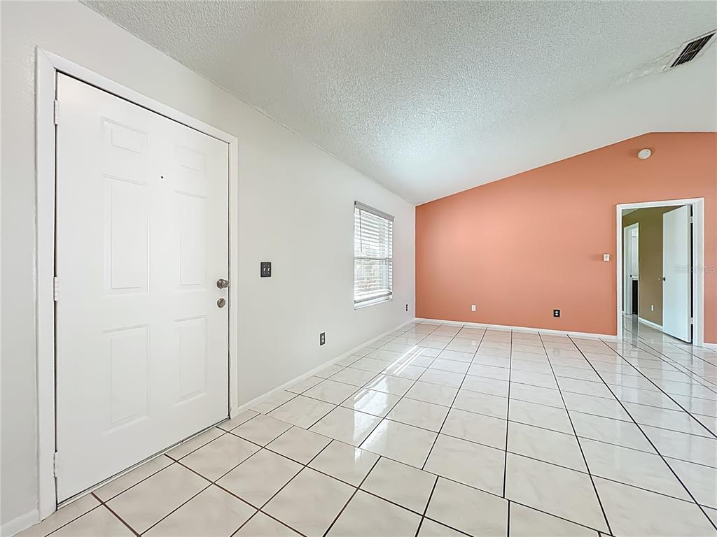 A single-story house with a brown roof, tan stucco walls, and a two-car garage — 6449 ROYAL TERN STREET, ORLANDO, FL