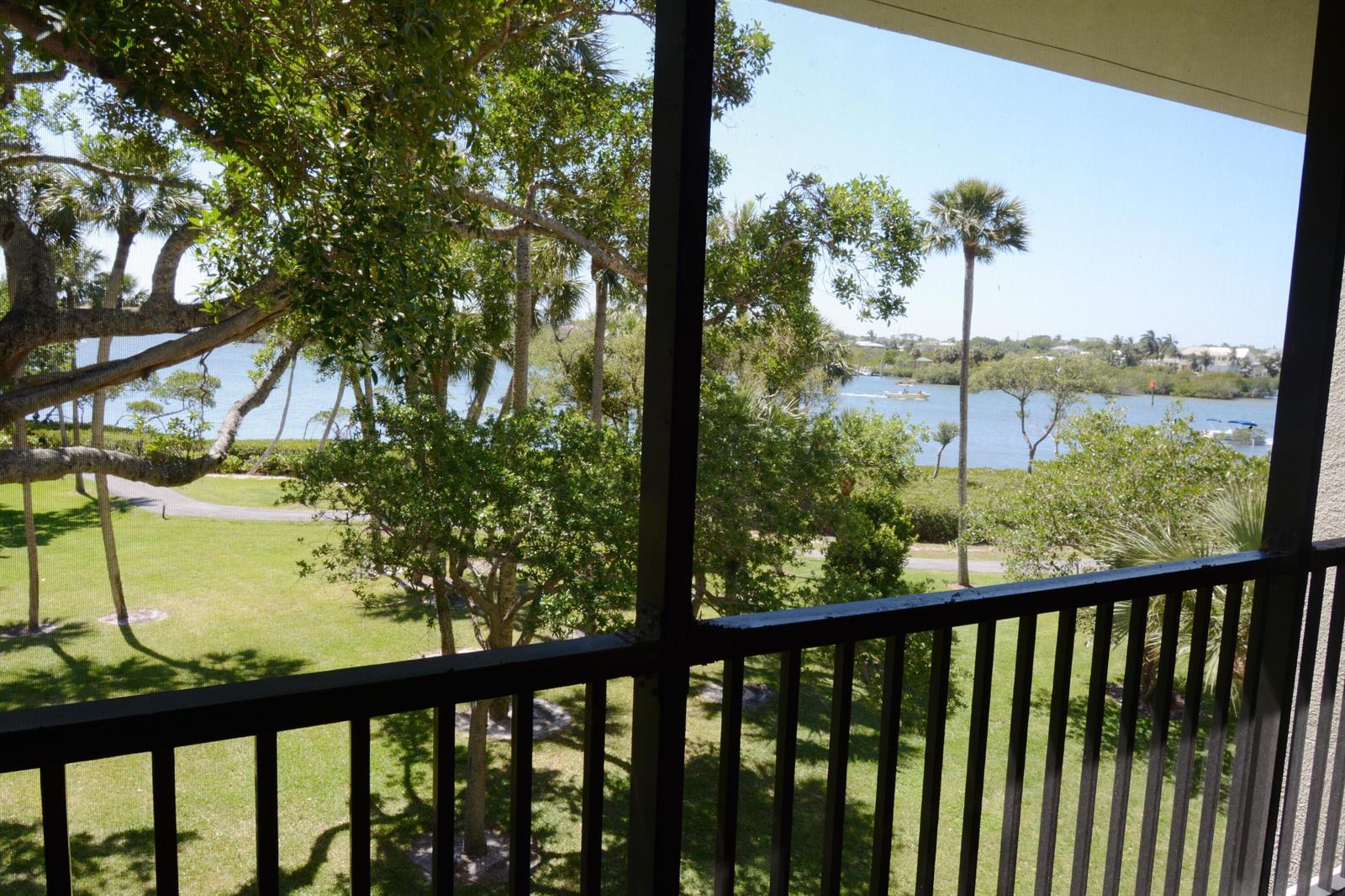 A view of a grassy lawn, trees, and a waterway from a screened-in balcony — 1000 N Us Highway 1, Jupiter FL 33477, JUPITER, FL