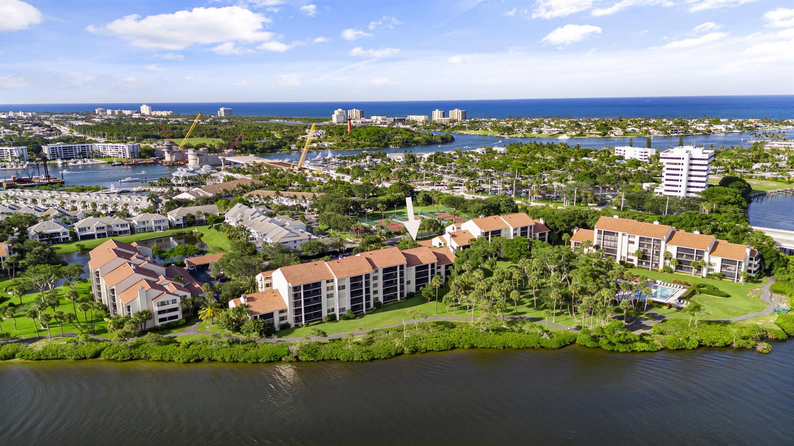 An aerial view shows multi-story residential buildings with tile roofs situated along a waterfront — 1000 N Us Highway 1, Jupiter FL 33477, JUPITER, FL