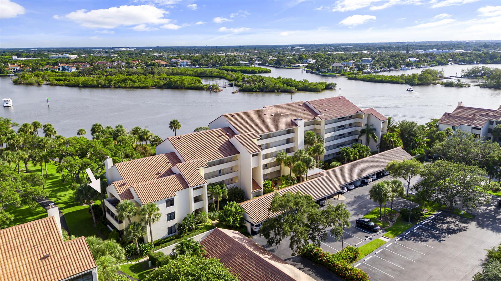 An aerial view shows a multi-story apartment complex with tile roofs situated near a waterway — 1000 N Us Highway 1, Jupiter FL 33477, JUPITER, FL