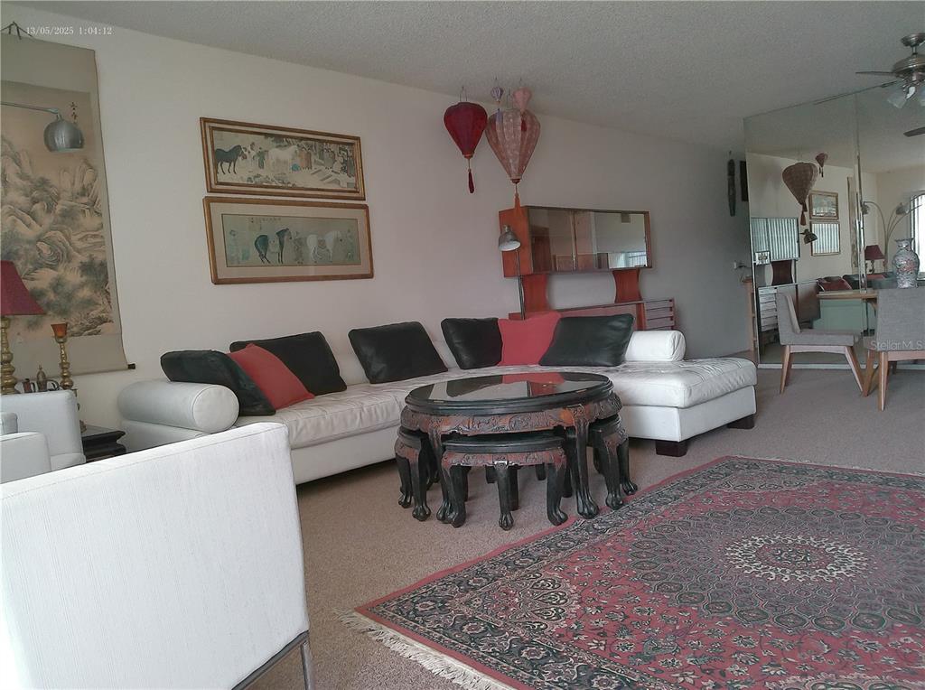 A living room features a white sectional sofa, a round coffee table, and Asian-inspired decor — 2361 ECUADORIAN WAY UNIT 45, CLEARWATER, FL