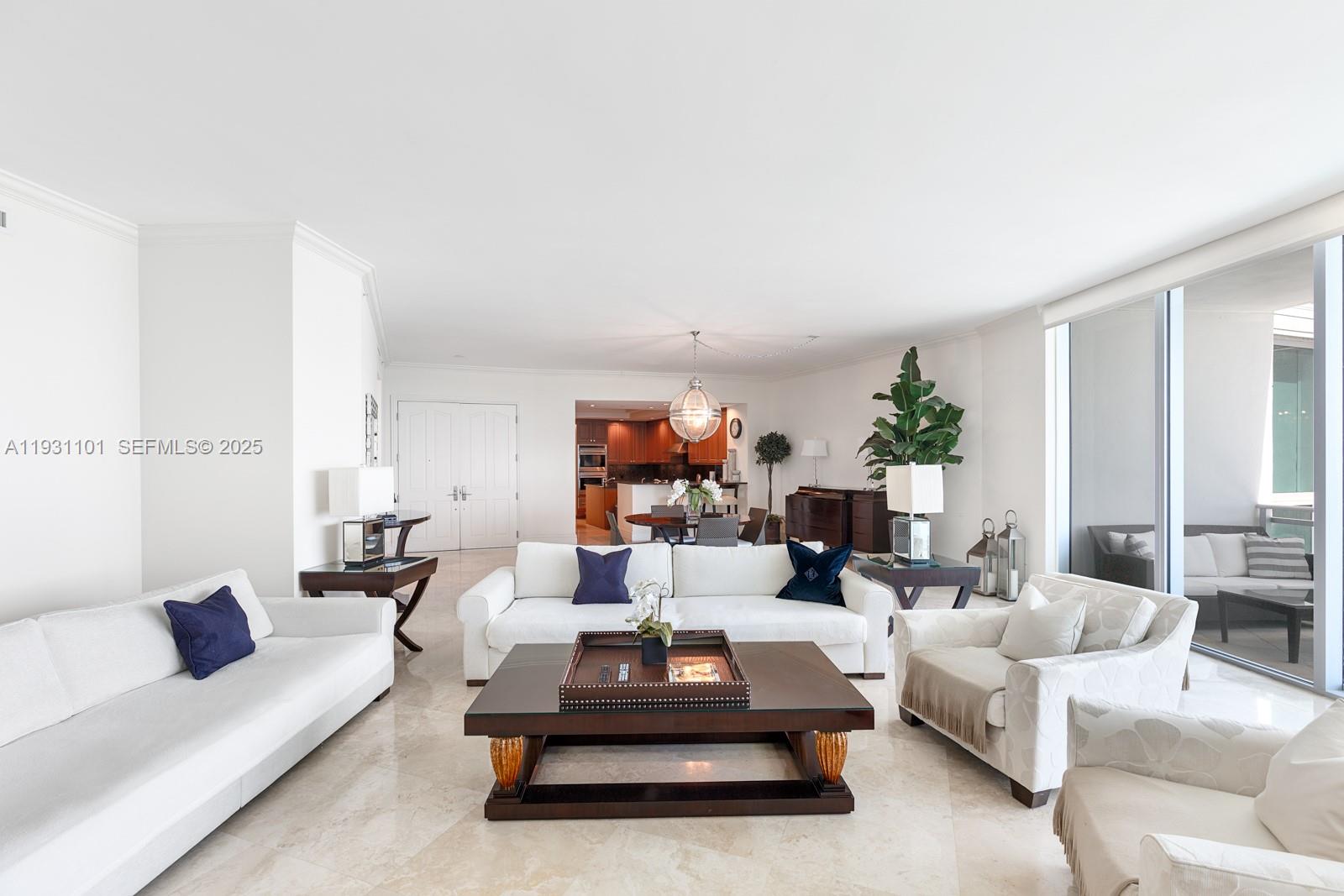 A bright living room features white sofas, a dark wood coffee table, and marble flooring — 10295 Collins Ave # 803, Bal Harbour FL 33154, BAL HARBOUR, FL
