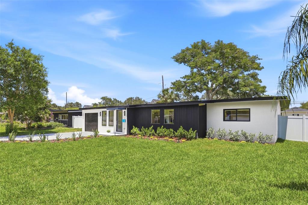 A single-story house with a black and white exterior, flat roof, and a large lawn — 3006 NORTHWOOD BOULEVARD, WINTER PARK, FL