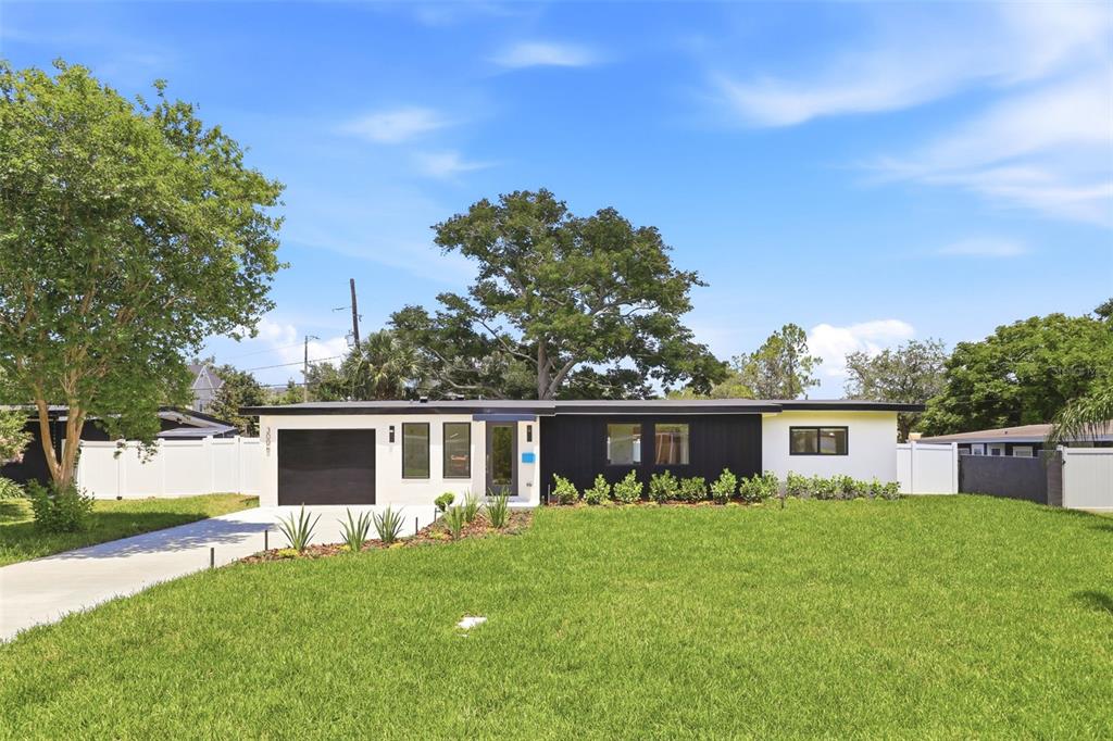 A modern, single-story house with a black and white exterior and a front lawn — 3006 NORTHWOOD BOULEVARD, WINTER PARK, FL