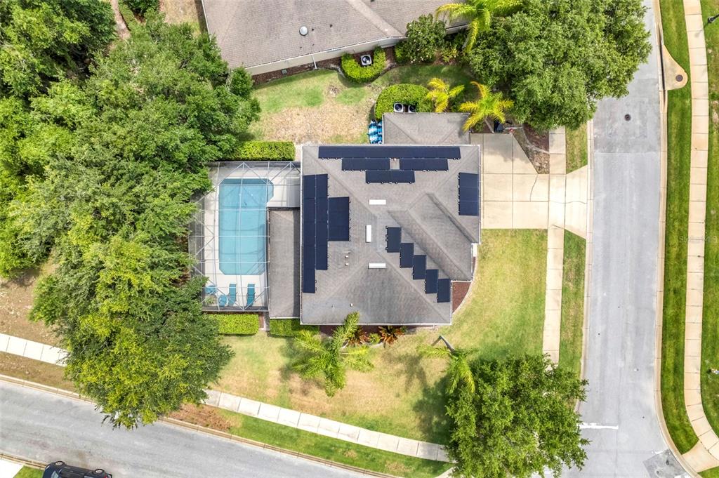An aerial view shows a house with a pool enclosure and solar panels on the roof — 159 RED MAPLE BURL CIRCLE, DEBARY, FL