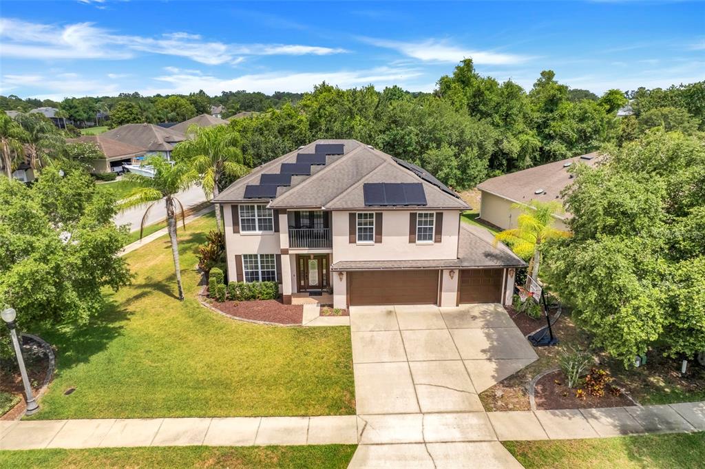 An aerial view of a two-story suburban house with solar panels on the roof — 159 RED MAPLE BURL CIRCLE, DEBARY, FL