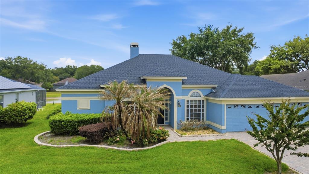 A blue single-story house with a dark shingled roof and a paved driveway — 120 BLUE STONE CIRCLE, WINTER GARDEN, FL