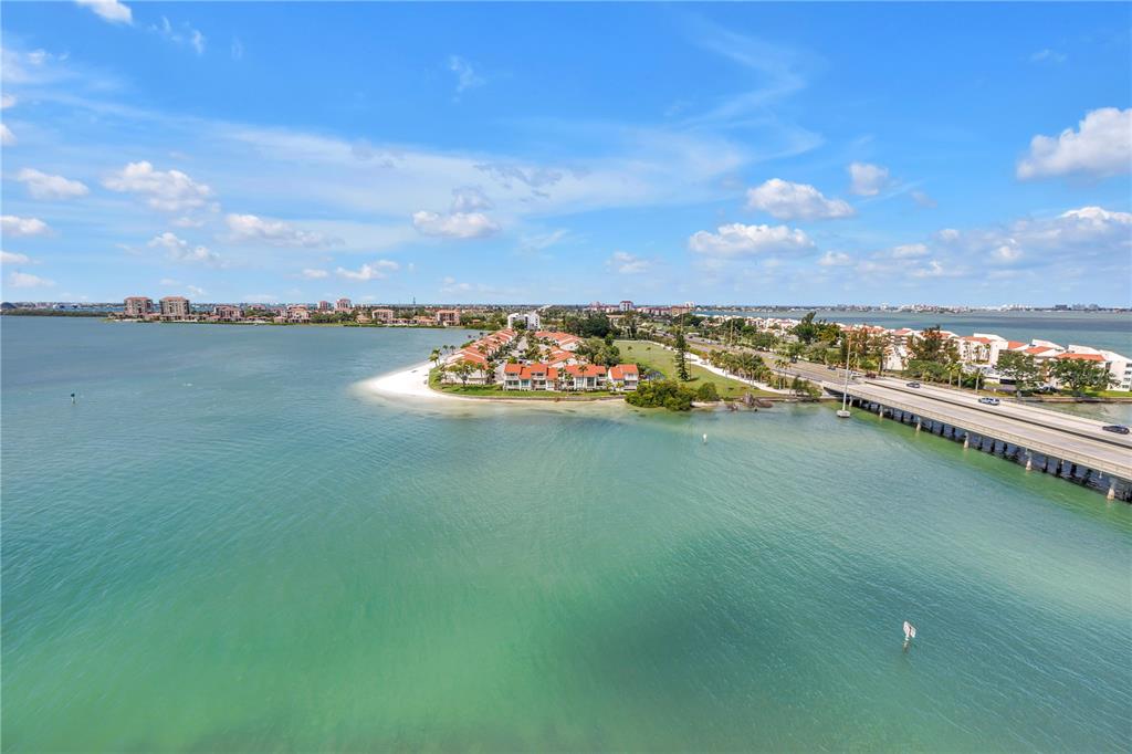 An aerial view shows a coastal residential complex on a peninsula next to a bridge — 5220 BRITTANY DRIVE S UNIT 1202, ST PETERSBURG, FL
