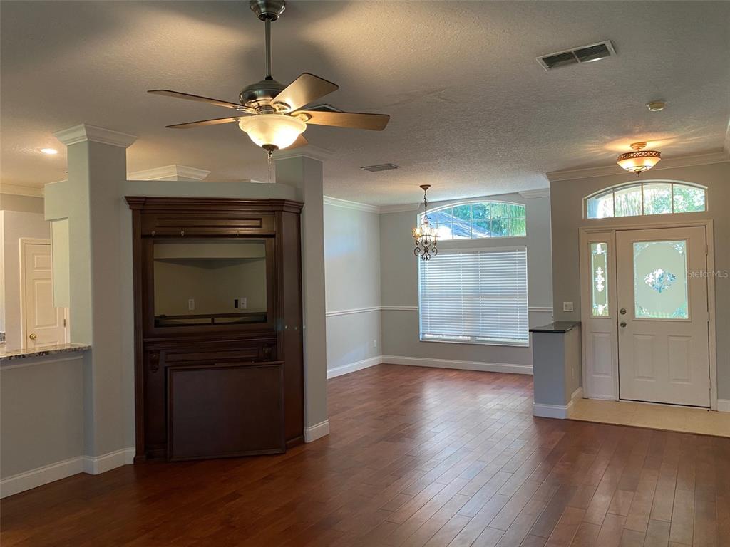 A living area features wood flooring, a built-in entertainment center, and a front entryway — 460 PICKFAIR TERRACE, LAKE MARY, FL