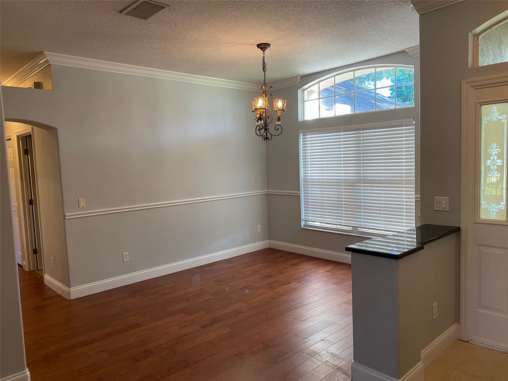 A dining room with hardwood floors, a chandelier, chair rail molding, and a large window — 460 PICKFAIR TERRACE, LAKE MARY, FL