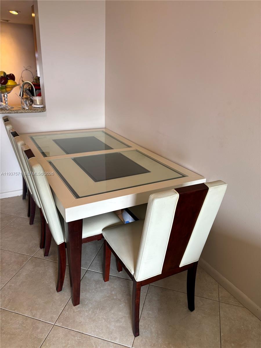 A dining area features a glass-topped table with white and dark wood chairs — 7690 NW 18th St # 408, Margate FL 33063, MARGATE, FL