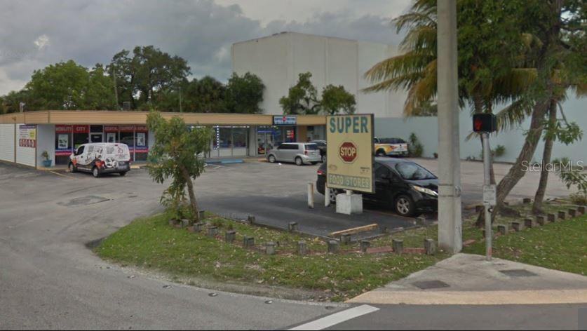 A commercial building with a parking lot and a Super Stop Food Stores sign — 1801 NE 45TH STREET, FORT LAUDERDALE, FL