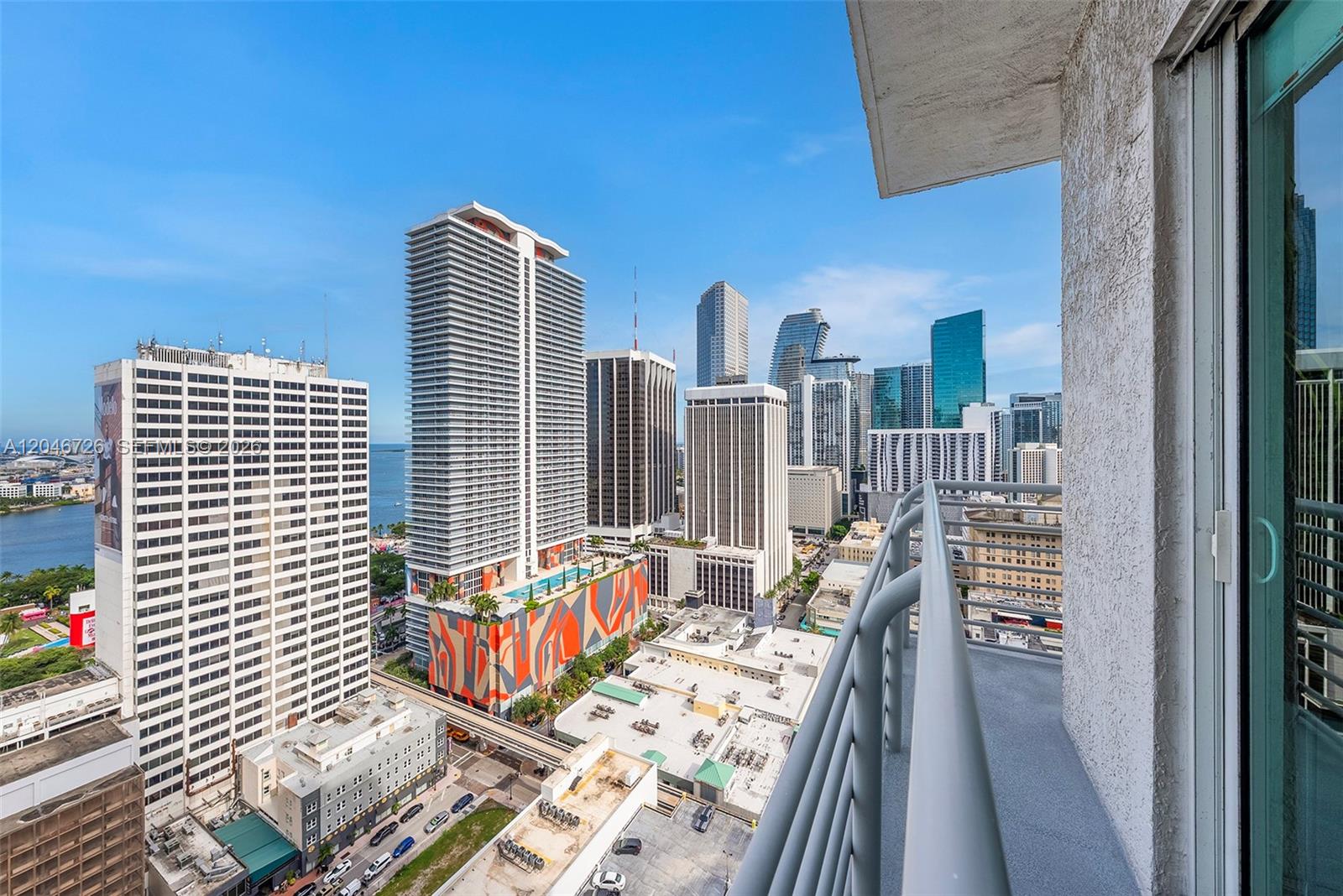 A high-angle view from a balcony overlooking a dense urban cityscape with multiple skyscrapers — 133 NE 2nd Ave # 2702, Miami FL 33132, MIAMI, FL