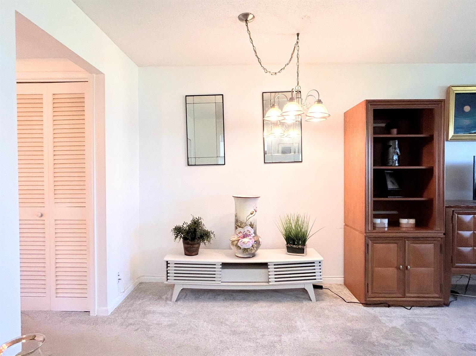 A living room features a white media console, a wooden cabinet, and a hanging chandelier — 320 Horizons # 103, Boynton Beach FL 33435, BOYNTON BEACH, FL