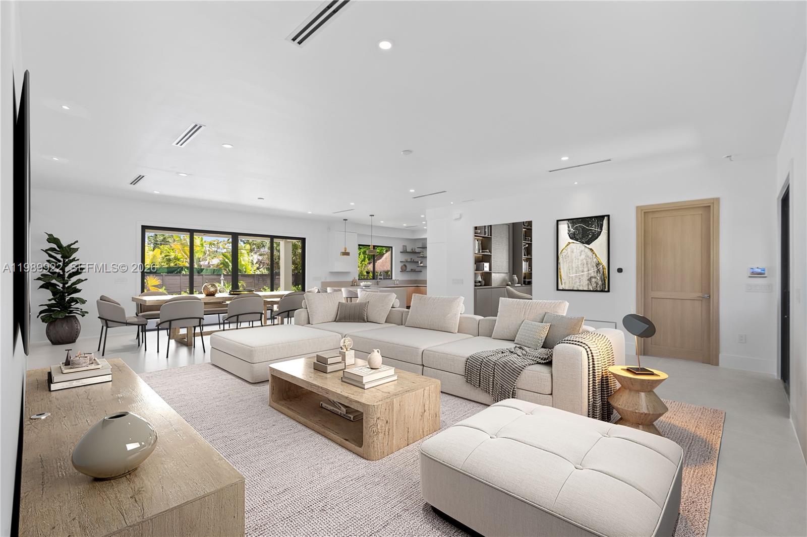 A modern open-concept living room features a large sectional sofa, wooden coffee table, and dining area — 6221 SW 60th St, South Miami FL 33143, SOUTH MIAMI, FL