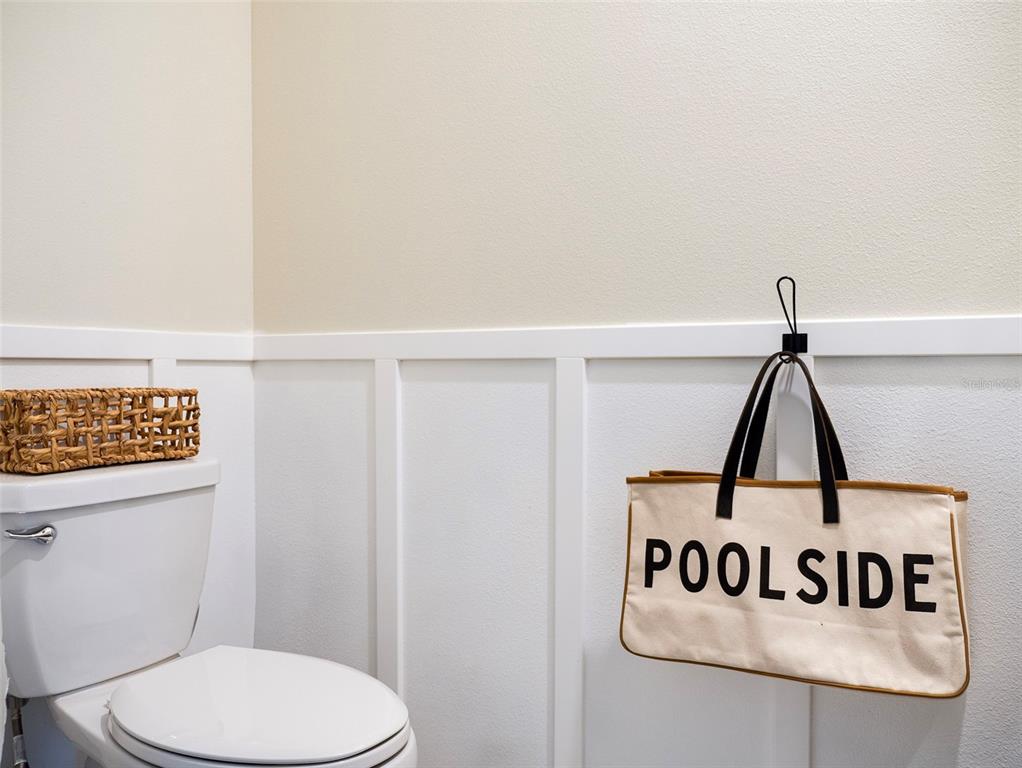 A bathroom features white board and batten wainscoting, a toilet, and a hanging tote bag — 2949 MULLER OAK LOOP, OCOEE, FL