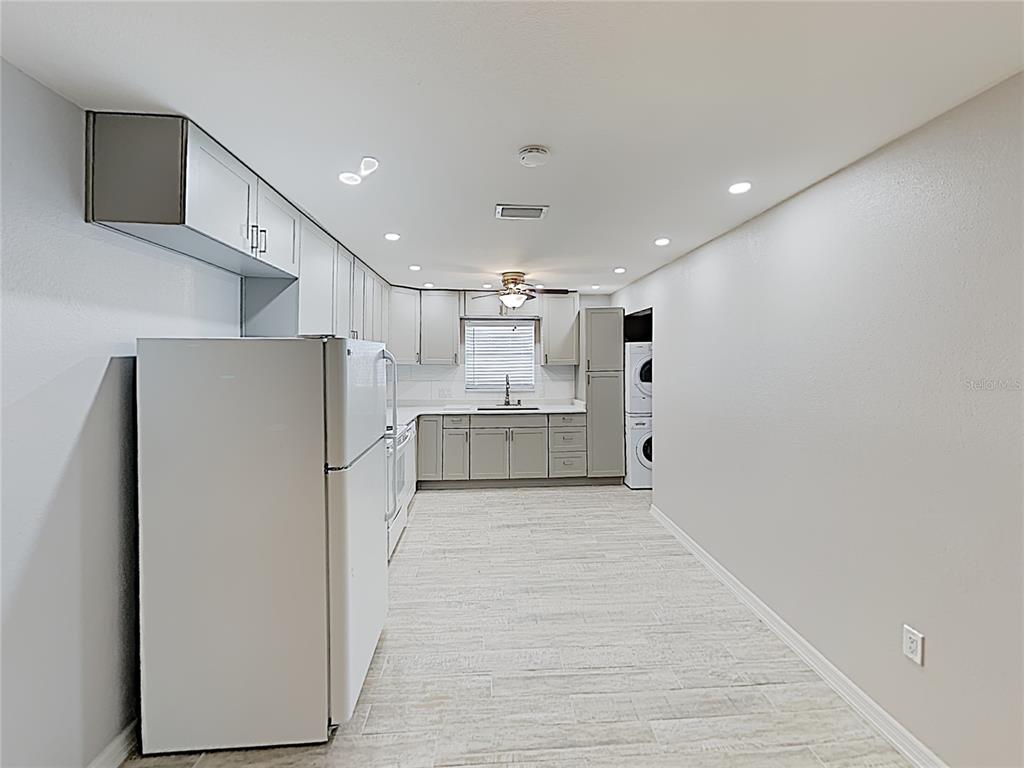 A kitchen with light gray cabinets, white appliances, and wood-look tile flooring — 525 CONWAY ROAD UNIT 91, ORLANDO, FL