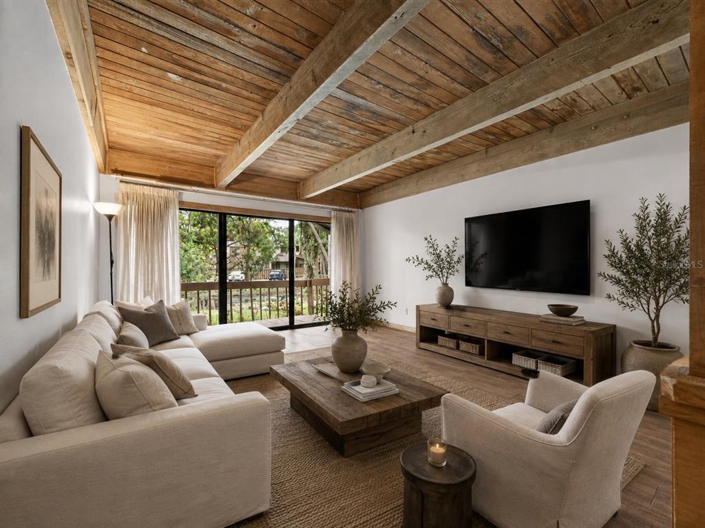 A living room features a wood-planked vaulted ceiling, a sectional sofa, and a large television — 5314 INDIAN CREEK DRIVE UNIT D08, ORLANDO, FL