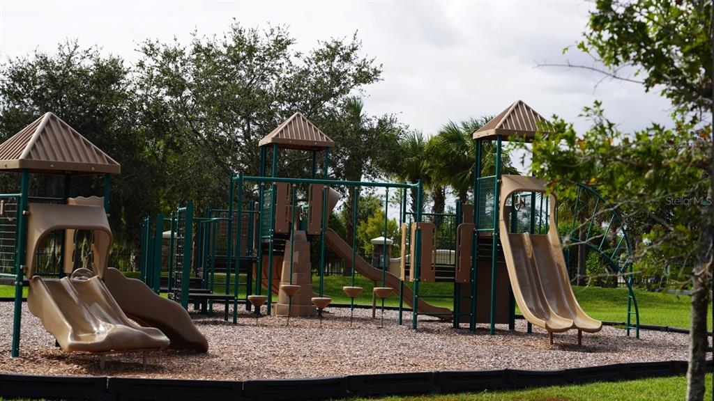 A playground with multiple slides, climbing structures, and a wood chip ground cover — 1754 BOAT LAUNCH ROAD, KISSIMMEE, FL