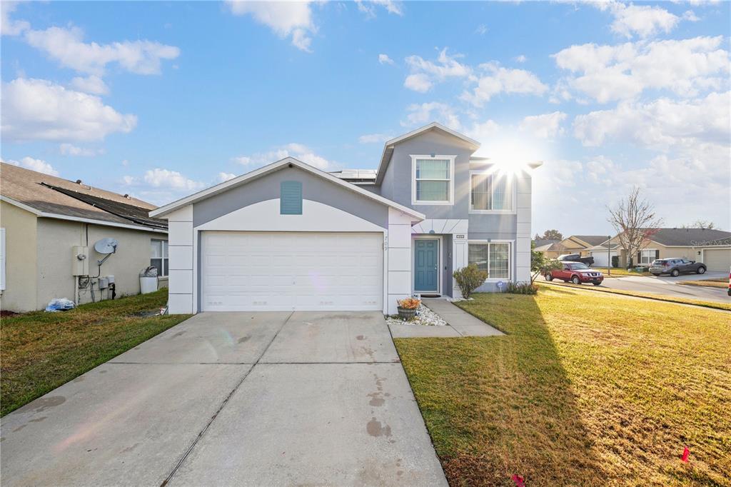 A two-story suburban house with a gray exterior, a two-car garage, and a blue front door — 709 CLIFTON HILLS STREET, ORLANDO, FL