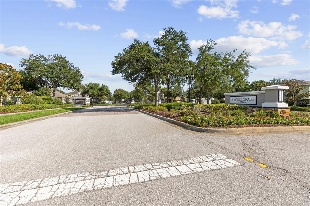 A paved road leads to the entrance sign of the Sweetgrass community — 2719 CYPRESS BOWL ROAD, LUTZ, FL