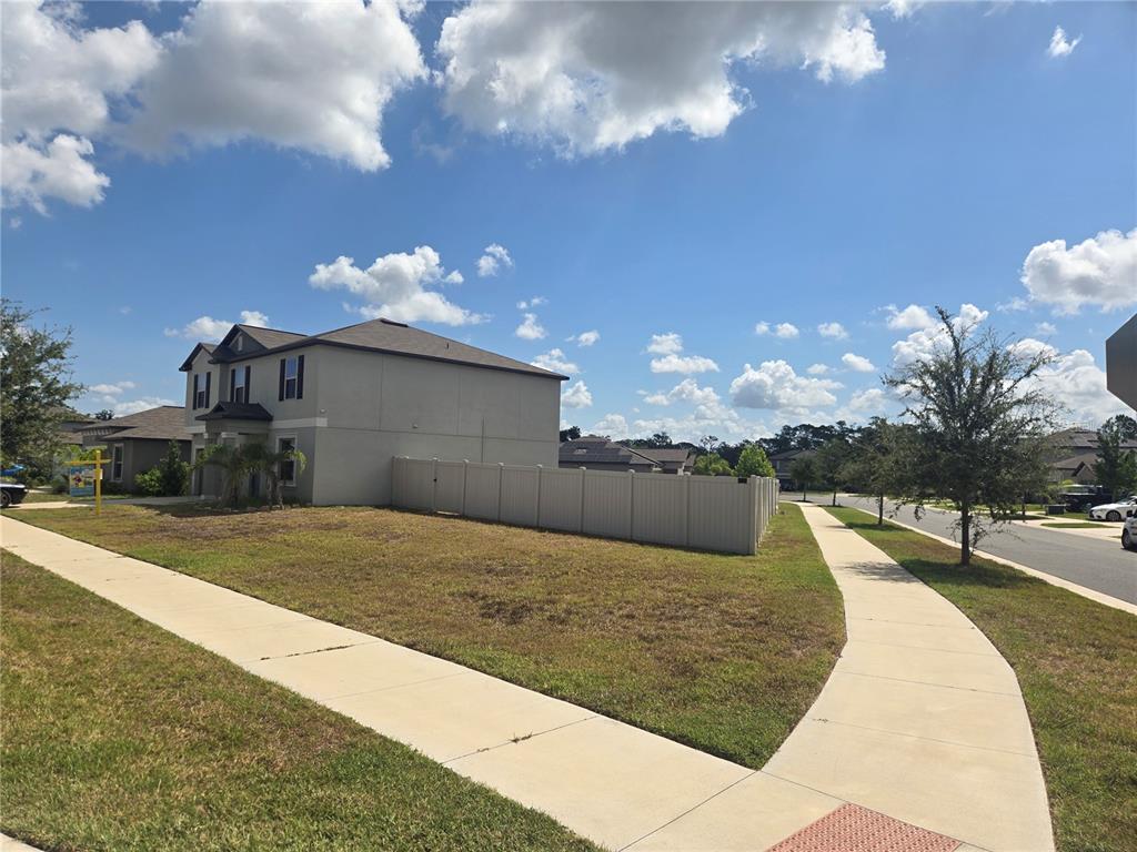 A two-story house with a fenced side yard sits on a corner lot — 1876 COLDING DRIVE, RUSKIN, FL