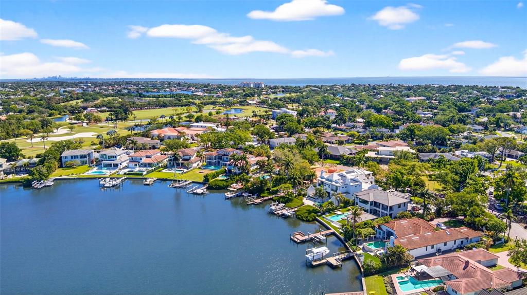 An aerial view shows waterfront luxury homes with private docks and pools along a bay — 460 COFFEE POT RIVIERA NE, ST PETERSBURG, FL