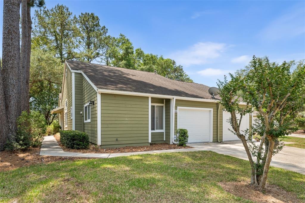 A green-sided house with a white garage door and a concrete driveway — 839 NW 125TH DRIVE, NEWBERRY, FL