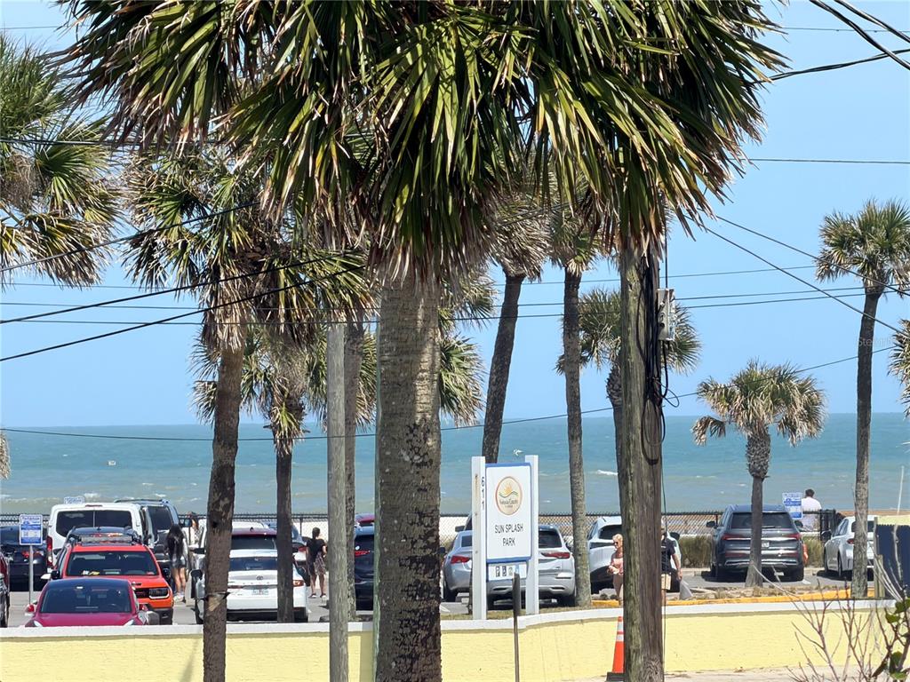 A parking lot with palm trees and a beach view at Sun Splash Park — 538 REVILO BOULEVARD, DAYTONA BEACH, FL