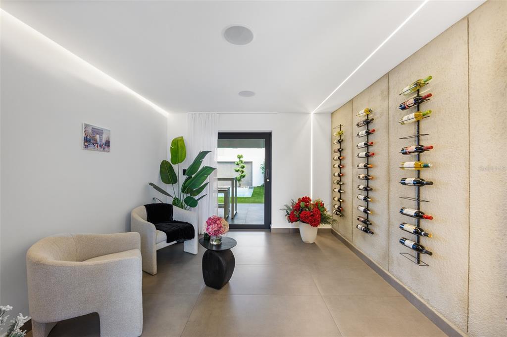 A modern room features a wall-mounted wine rack, two armchairs, and a glass door — NN1 CALLE NACAR, DORADO DEL MAR, DORADO, PR
