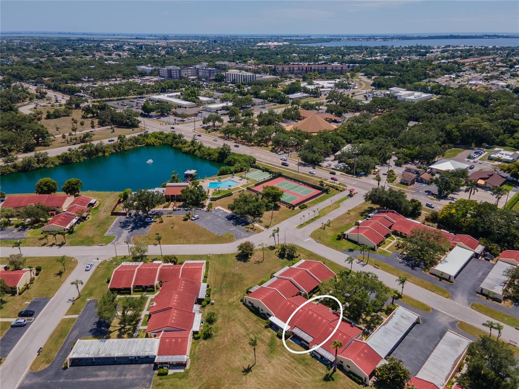 An aerial view shows a residential complex with red-roofed buildings and a circled unit — 1407 58TH STREET W UNIT 1407, BRADENTON, FL