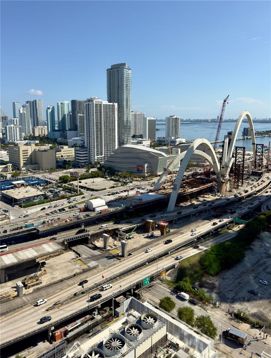 An elevated view of a city skyline featuring a large bridge under construction — 20 NE 11th St # 3006A, Miami FL 33132, MIAMI, FL
