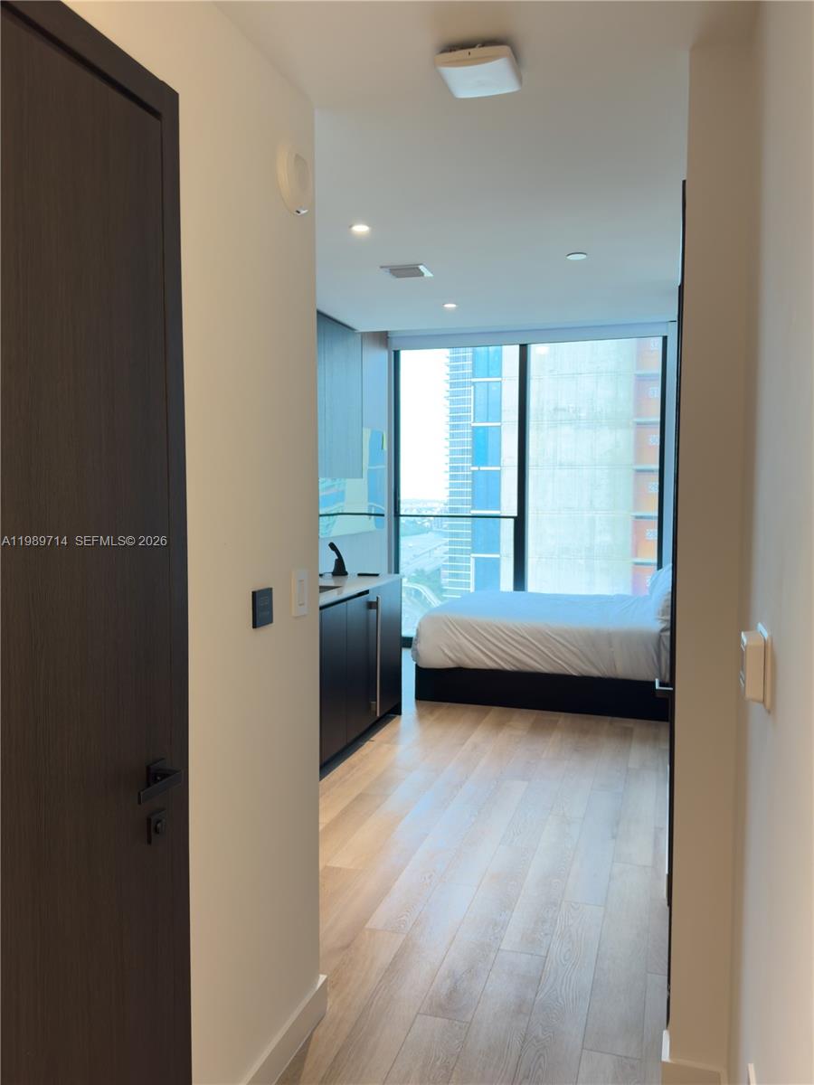 A view from a doorway into a studio apartment with a kitchenette and bedroom area — 20 NE 11th St # 3006A, Miami FL 33132, MIAMI, FL