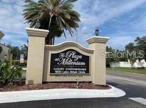 A stone monument sign for The Plaza at Millenium stands near a palm tree — 1948 LAKE ATRIUMS CIRCLE UNIT 127, ORLANDO, FL