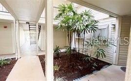 A covered outdoor walkway leads to a small garden area with palm trees and stairs — 1948 LAKE ATRIUMS CIRCLE UNIT 127, ORLANDO, FL