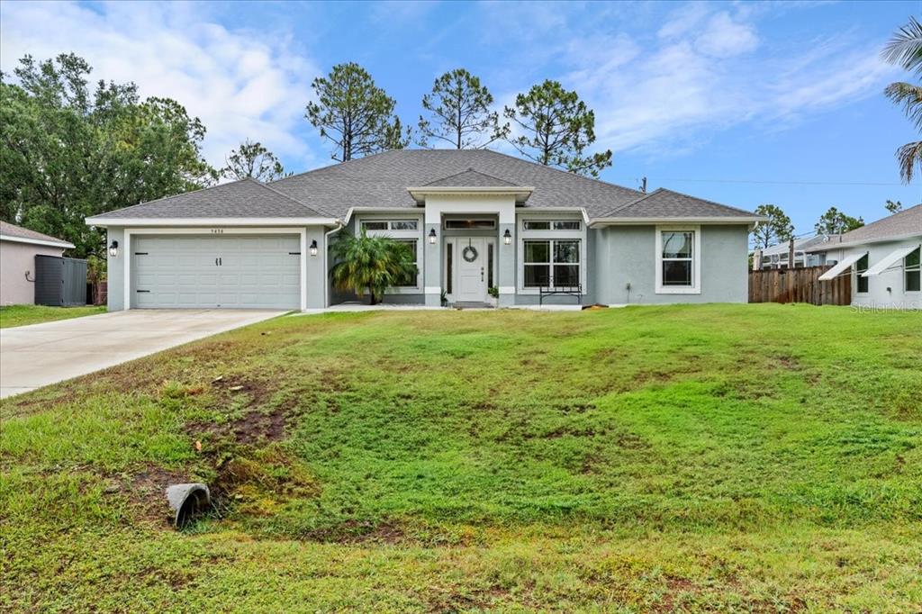 A single-story house with a gray exterior, a two-car garage, and a grassy front yard — 5436 JESSAMINE AVENUE, NORTH PORT, FL