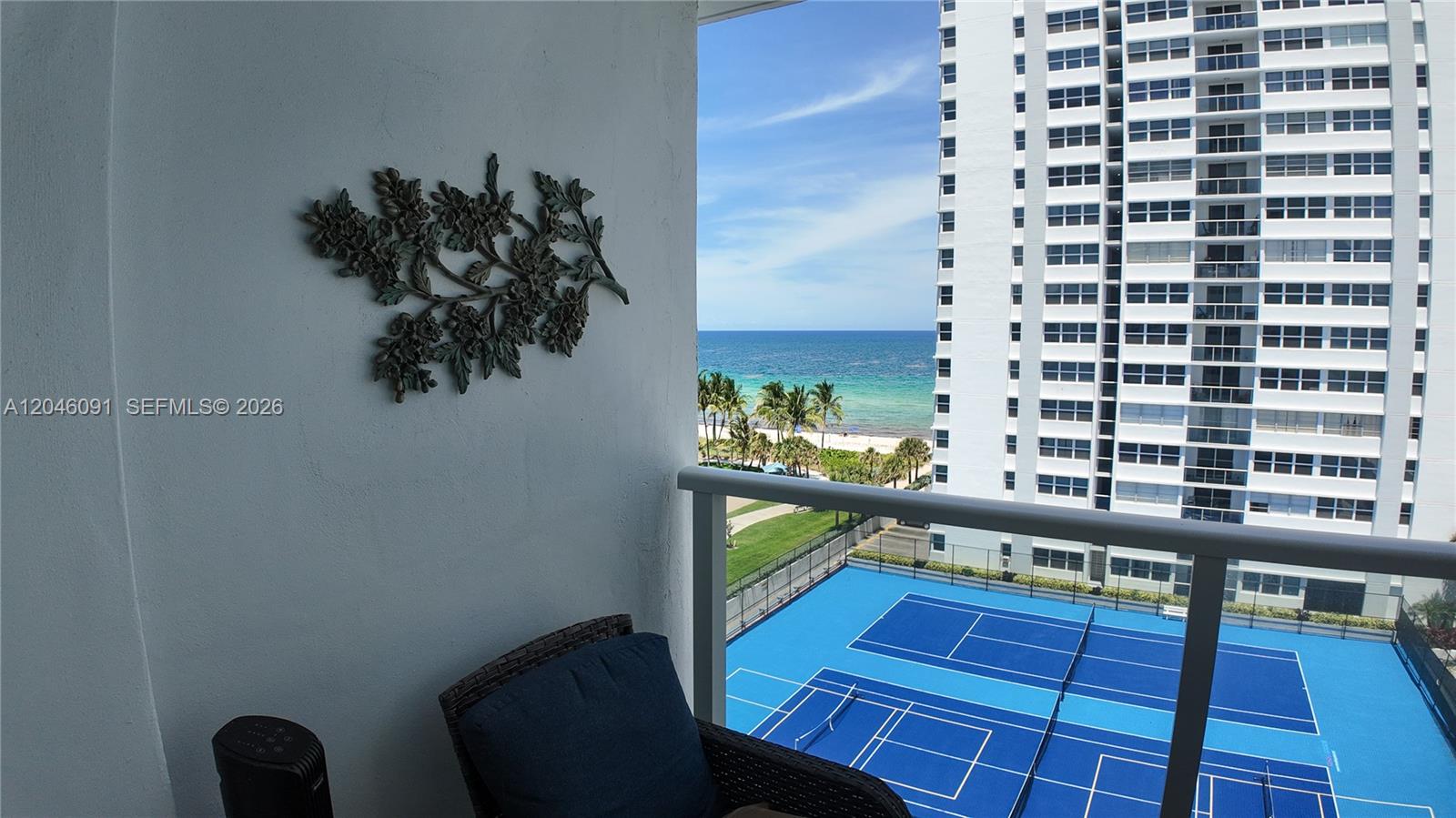 A balcony overlooks a tennis court, a beach, and the ocean next to a high-rise building — 1880 S Ocean Dr # 807, Hallandale Beach FL 33009, HALLANDALE BEACH, FL