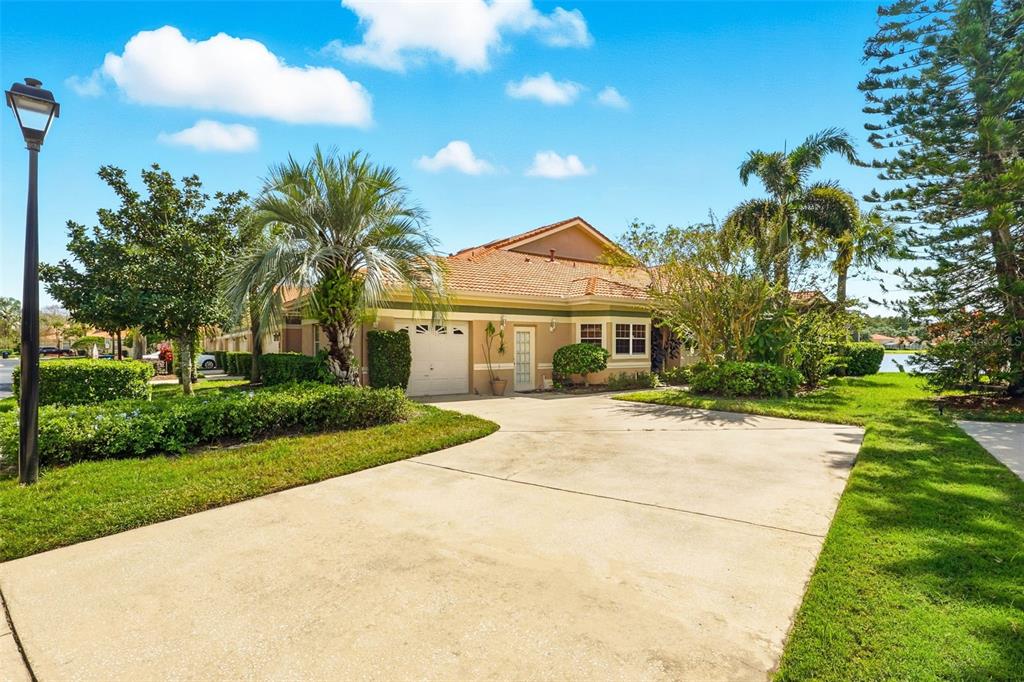 A single-story house with a tan exterior, tile roof, and a concrete driveway — 4870 WATERVISTA DRIVE, ORLANDO, FL
