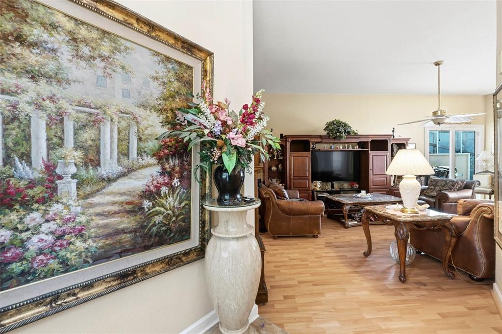 A living room with wood flooring, leather furniture, and a large painting on the wall — 4870 WATERVISTA DRIVE, ORLANDO, FL