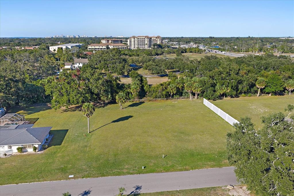 An aerial view shows a vacant grassy lot bordered by a road and trees — SOUTHWOOD STREET, SARASOTA, FL