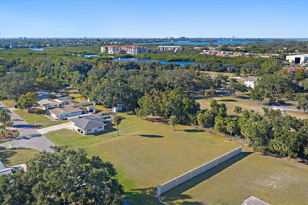 An aerial view shows a residential lot with a white fence near a suburban neighborhood — SOUTHWOOD STREET, SARASOTA, FL