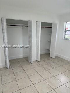 A room with light-colored tile flooring and two white louvered-door closets — 1074 NW 27th St # 0, Miami FL 33127, MIAMI, FL