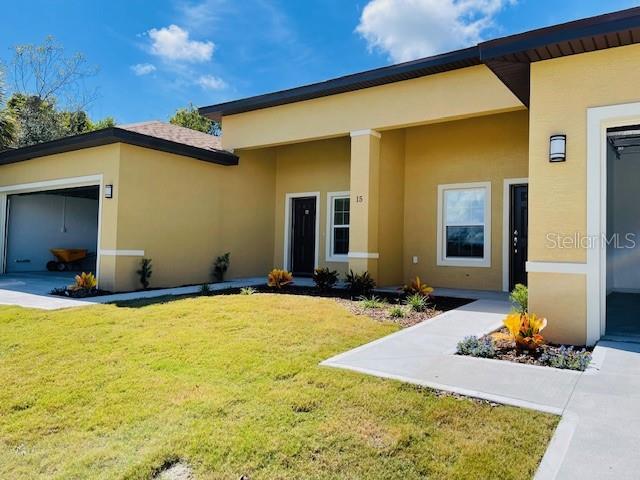 A yellow stucco house features a garage, a front entrance, and a landscaped yard — 15 CRABTREE COURT UNIT B, PALM COAST, FL