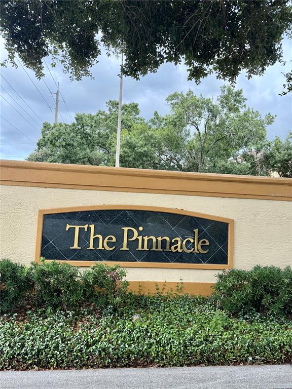 A sign for The Pinnacle is mounted on a tan stucco wall with landscaping below — 5612 PINNACLE HEIGHTS CIRCLE UNIT 302, TAMPA, FL