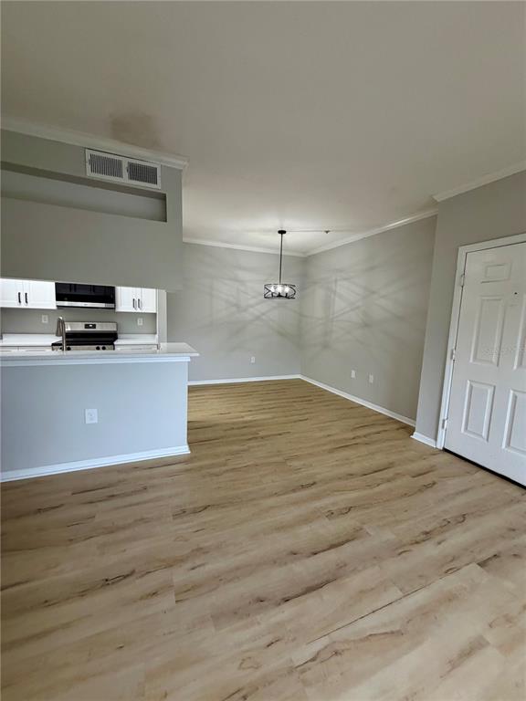 An open-concept kitchen and dining area features light wood-look flooring and a modern pendant light — 5612 PINNACLE HEIGHTS CIRCLE UNIT 302, TAMPA, FL