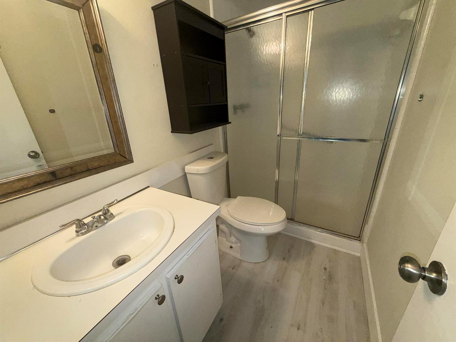 A bathroom features a white vanity, a toilet, a shower stall, and a wall-mounted cabinet — 4759 Sable Pine Circle # A2, West Palm Beach FL 33417, WEST PALM BEACH, FL