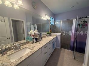 A bathroom features a granite-topped vanity with a single sink and a glass-enclosed shower — 1881 W ISLES ROAD, PORT CHARLOTTE, FL
