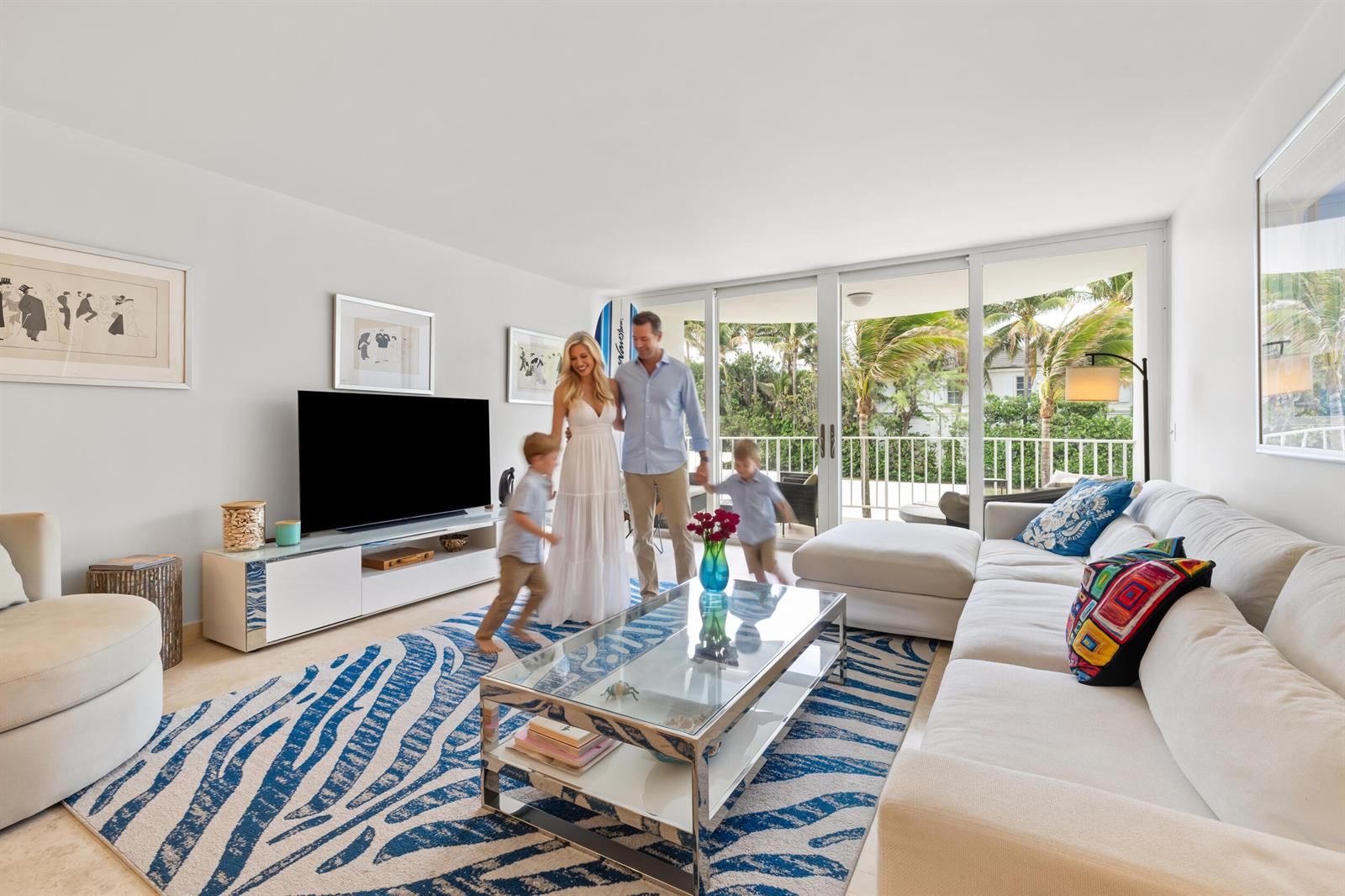 A living room with a blue and white patterned rug, white sofa, and balcony view — 2295 S Ocean Boulevard # 302, Palm Beach FL 33480, PALM BEACH, FL