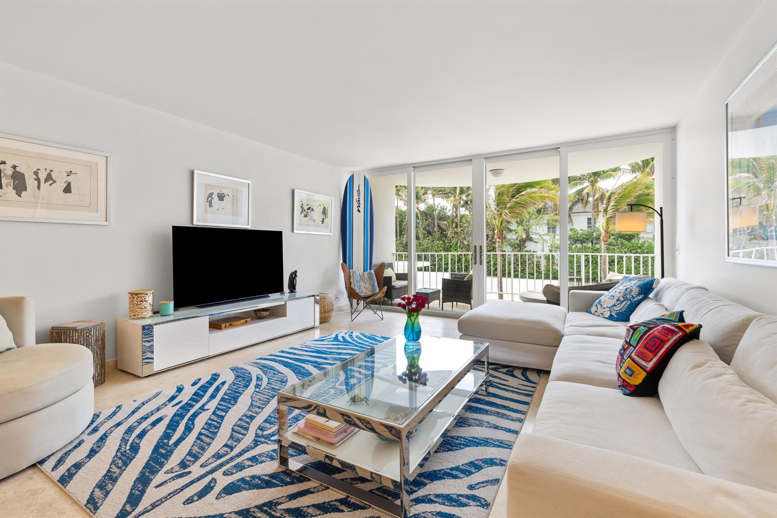 A living room features a white sectional sofa, blue zebra-print rug, and a glass coffee table — 2295 S Ocean Boulevard # 302, Palm Beach FL 33480, PALM BEACH, FL