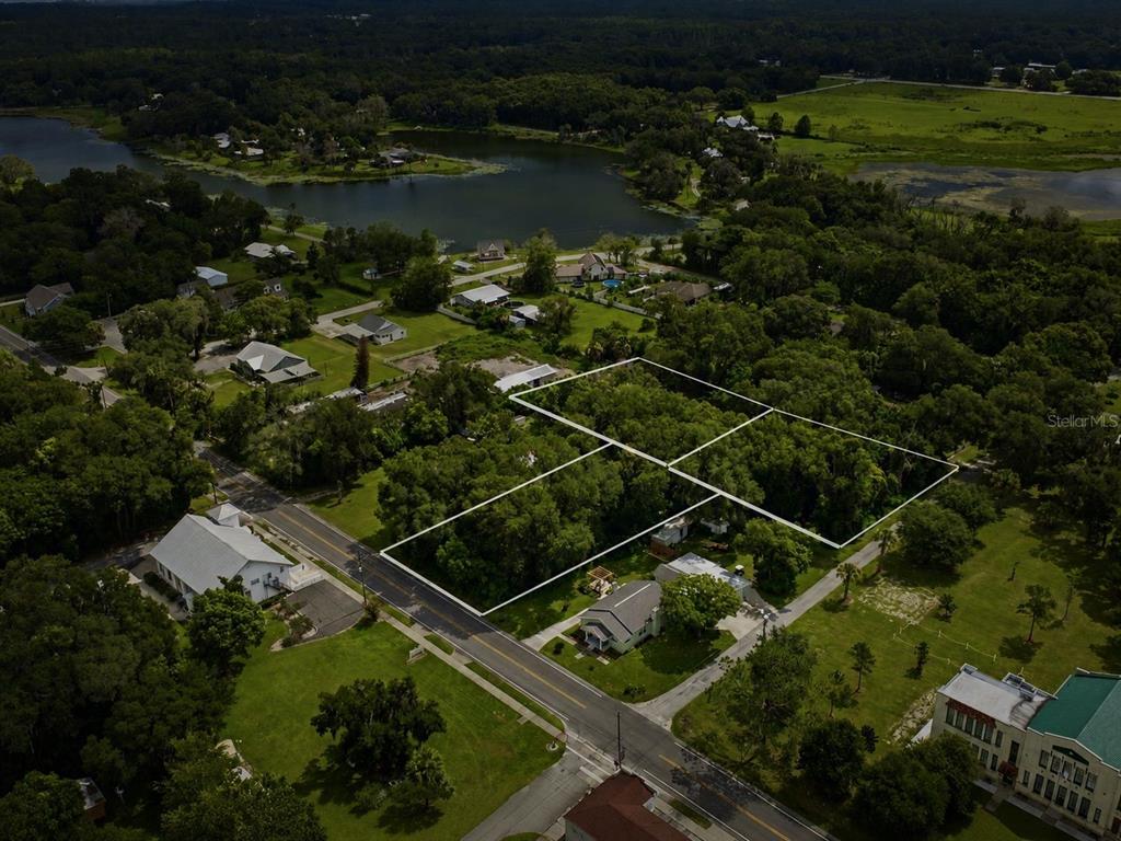 An aerial view shows a wooded lot outlined in white near a road and lake — S LAKEVIEW DRIVE, LAKE HELEN, FL